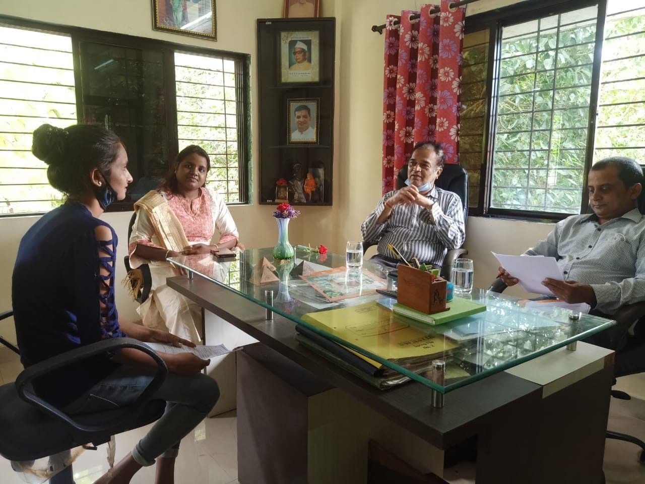 A student in discussion with college staff in an office on campus