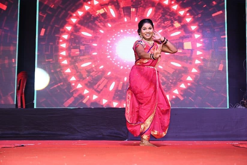 A student in a pink saree performing a dance at the Annual Fashion Show and Annual Gathering 2026