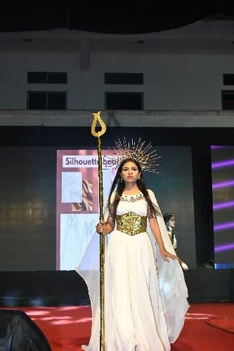 A model in a white gown and headdress on the ramp at the Annual Fashion Show 2026
