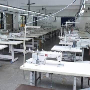 Rows of industrial sewing machines in the garment workshop