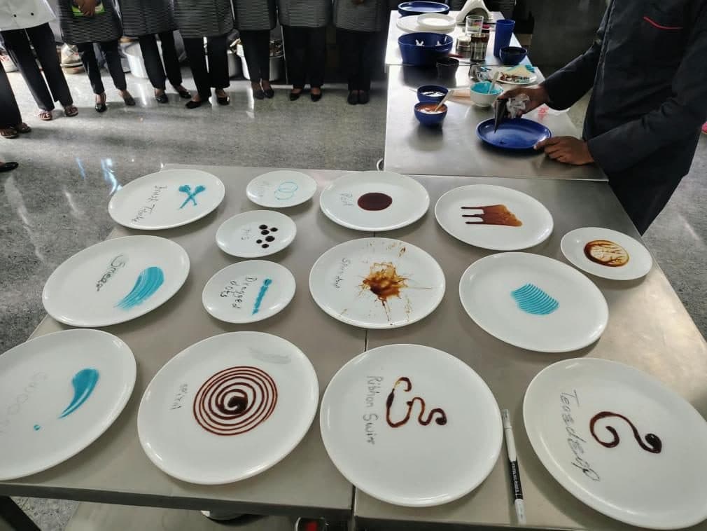 Plates decorated with sauce designs during a food plating activity