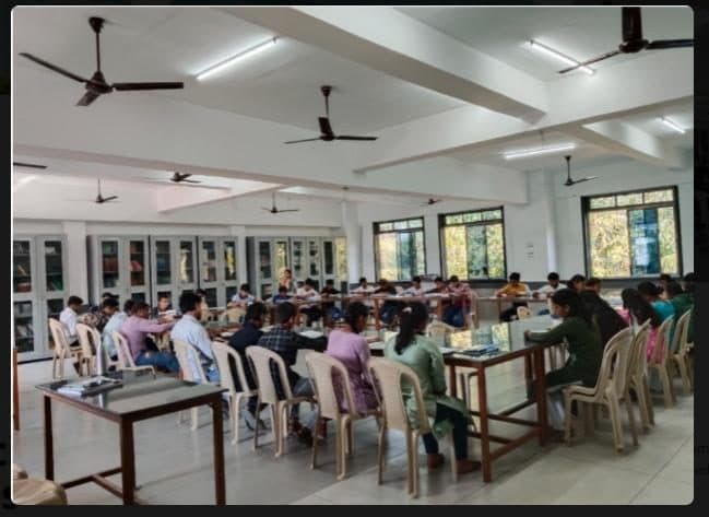 Students reading at tables in the library