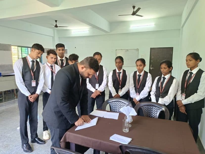 Students in service uniform watching a table demonstration