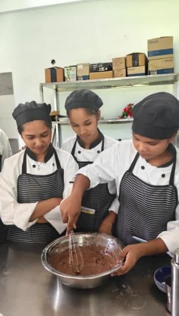 Students mixing chocolate batter in a bakery practical