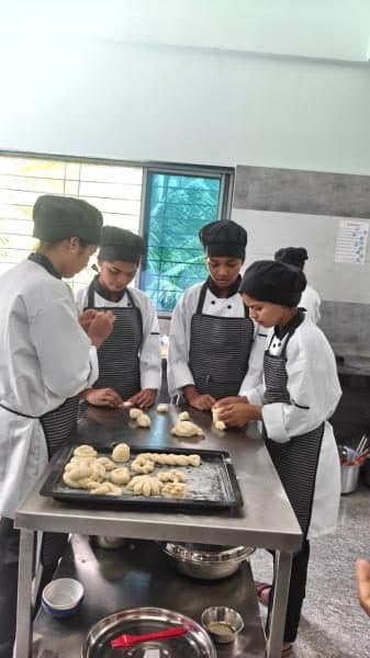 Students shaping dough on a baking tray