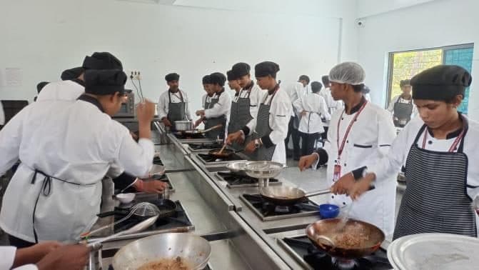 Students cooking at a row of ranges