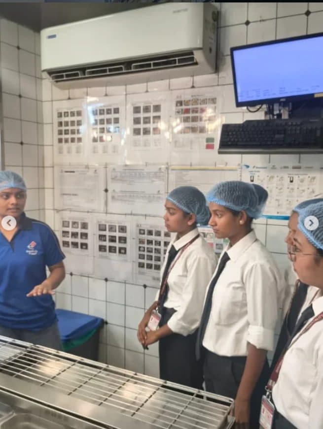 Students in hairnets being shown the Domino’s kitchen