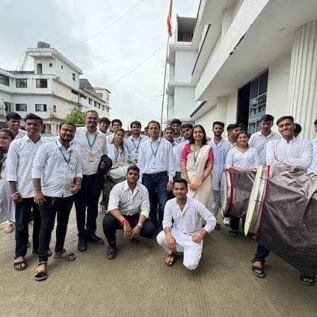 Students with dhol drums in front of the college building